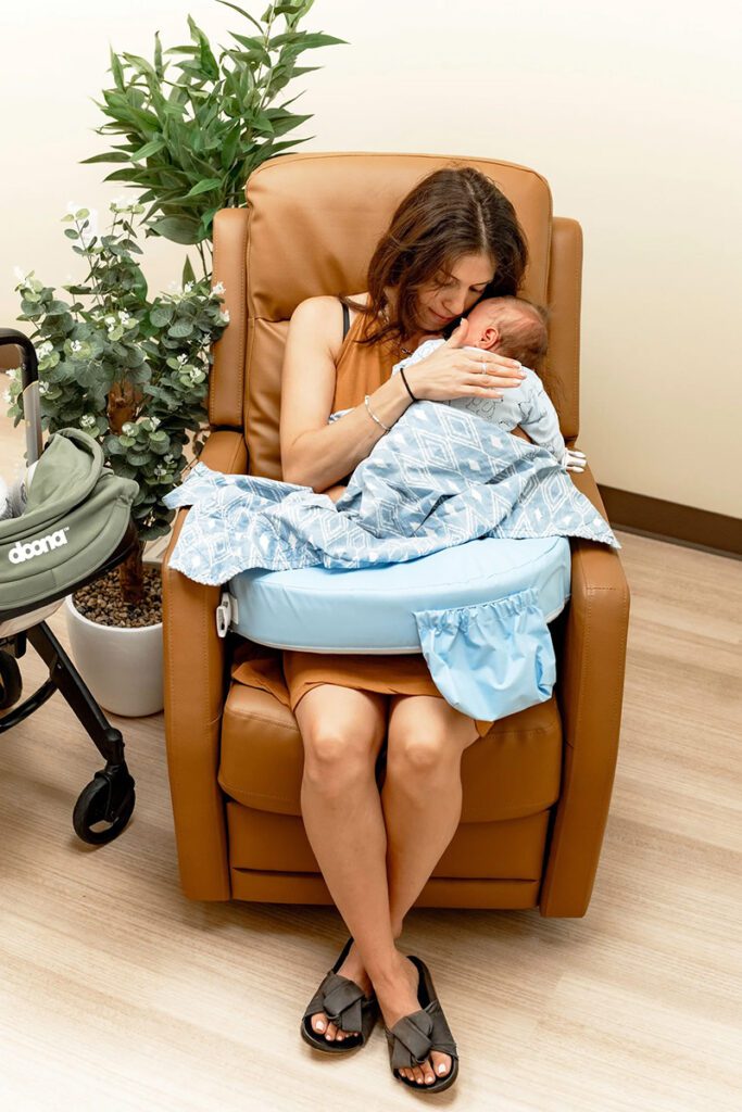 Mother holding infant during pediatric tongue-tie consultation
