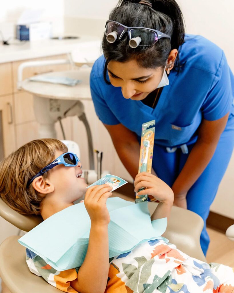 Pediatric dentist reassuring child during dental appointment