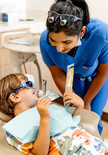 Pediatric dentist reassuring child during dental appointment