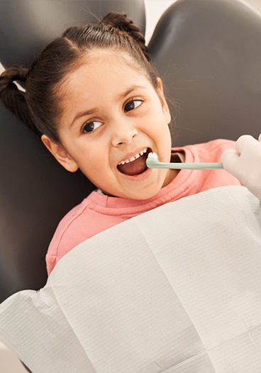 Child receiving gentle pediatric dental care during emergency visit